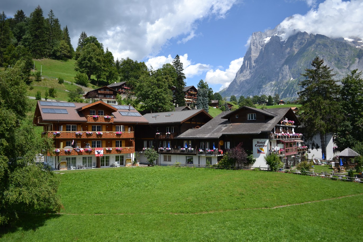 Hotel Caprice in Grindelwald with alpine chalet architecture and mountain backdrop